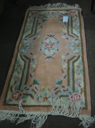 A peach ground and floral patterned Chinese rug 47" x 25"