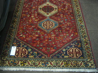 A Persian red ground rug with 3 medallions to the centre within multi-row borders 73" x 37"