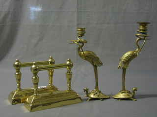 A pair of brass fire dogs together with 2 Oriental brass candlesticks in the form of storks raised upon trestles 11"