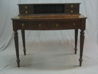 A 19th Century mahogany bow front writing table, the raised back fitted pigeon holes flanked by 4 short drawers, the base fitted 2 long drawers, raised on turned and reeded supports 42"