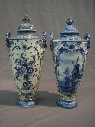 A pair of Delft blue and white pottery twin handled urns and covers, the base marked Royl Bonn Delft 12" high (1 lid f and r)