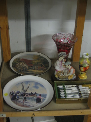 A red overlay glass trumpet shaped vase 8", 2 decorative wall plates, a pottery figure, 5 tea knives with knife and fork and a Worcester style vase