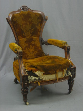 A Victorian carved walnut show frame open arm chair upholstered in orange material raised on turned supports (requires some attention)