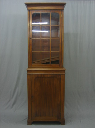 A walnut bookcase on cabinet, the upper section with moulded cornice enclosed by a glazed panelled door, the base fitted a cupboard enclosed by a panelled door, raised on bracket feet 34 "
