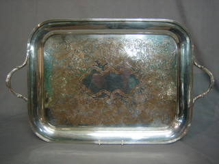 An engraved silver plated twin handled tea tray raised on 4 bun feet 20"