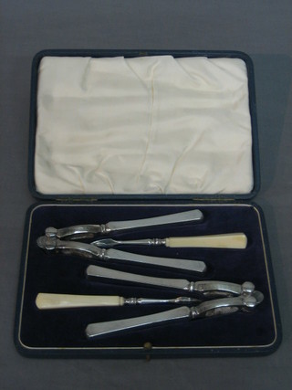 A pair of silver plated nut crackers together with a pair of silver plated nut picks (cased)