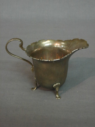 A Scotts silver cream jug with wavy border raised on 3 hoof feet, Edinburgh 1919, 2 ozs