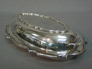 An oval silver plated twin handled entree dish and cover complete with china liner