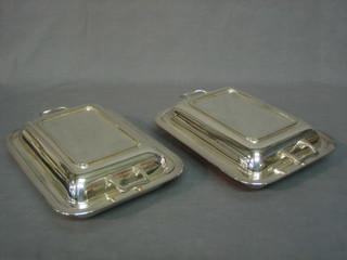 A pair of silver plated rectangular twin handled entree dishes and covers