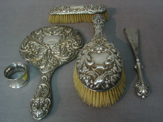 A silver backed hand mirror, a hair brush and clothes brush together with shoe horn and a napkin ring