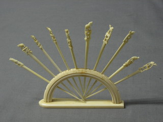 A carved ivory tooth pick holder with 10 various tooth picks