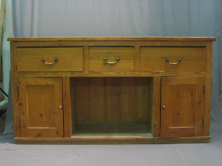 A Victorian stripped and polished pine dresser base fitted 3 drawers above a recess, flanked by a pair of cupboards, 74" 