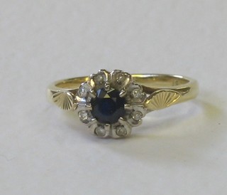 An 18ct gold dress ring set a sapphire surrounded by diamonds