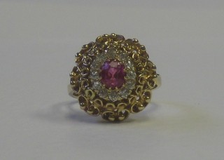 A lady's gold dress ring set an oval cut ruby surrounded by diamonds