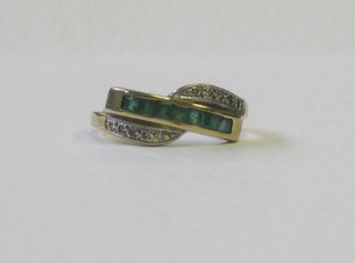A lady's gold dress ring set a square cut emerald supported by diamonds
