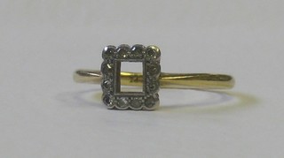 A gold dress ring (centre stone missing) supported by 2 diamonds