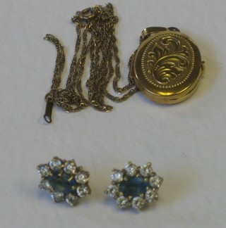 A gilt metal locket and a pair of ear studs set blue and white stones