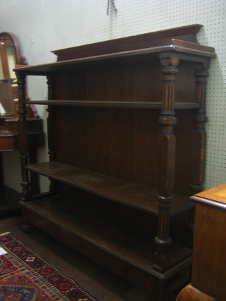 A Victorian oak open 3 tier bookcase, raised on turned and fluted columns raised on bun feet 54"
