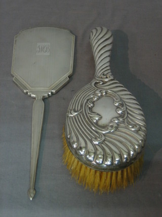 A silver backed hand mirror together with a hair brush
