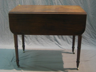 A 19th Century mahogany Pembroke table fitted a drawer, raised on turned supports, ending in brass caps and castors 36"