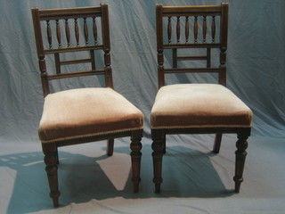 A pair of mahogany Aesthetic movement stick and bar back dining chairs with upholstered seats, raised on turned supports