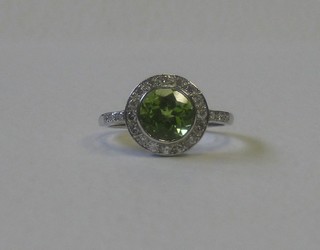A lady's 18ct yellow gold dress ring set a circular cut peridot surrounded by diamonds  and with diamonds to the shoulders