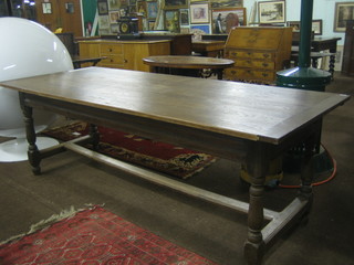 An oak refectory table, the antique base raised on a turned and block supports with H framed stretcher, with later top 85"