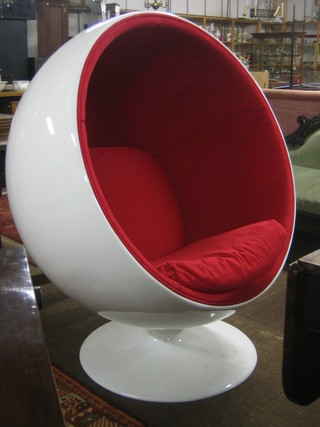 A white plastic framed Egg chair with red upholstered interior