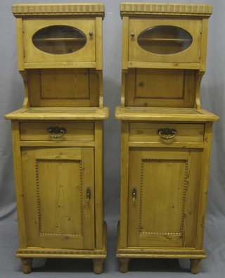 A pair of Continental pine bedside cabinets with raised back above recess, the base fitted 1 long drawer raised on turned supports 19"