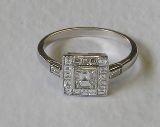 An 18ct white gold dress ring set a square cut diamond surrounded by numerous diamonds