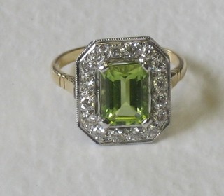 An 18ct yellow gold dress ring set a rectangular cut peridot surrounded by numerous diamonds (approx 0.15/3.60ct)