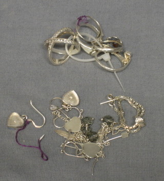 4 silver rings together with a collection of various earrings