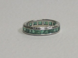 An 18ct white gold eternity ring set square cut emeralds