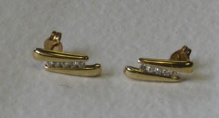 A pair of gilt metal earrings set white stones