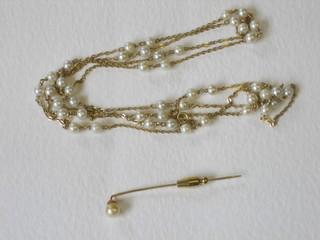 A gilt metal chain hung pearls together with a stick pin