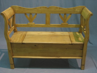 A Continental stripped and polished pine settle with hinged seat 47"