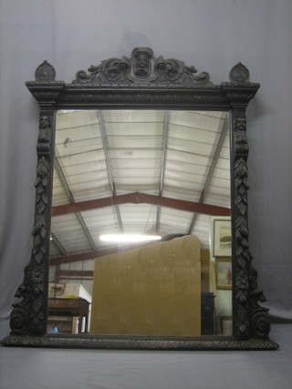 A Victorian rectangular plate mirror contained in a carved oak frame with carved mask decoration 50"x39"