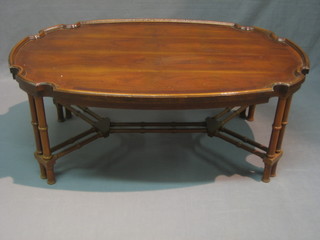 A Georgian style oval occasional table with bracketed border, raised on turned supports with X frame stretcher
