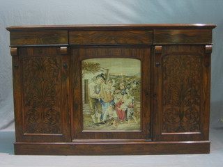 A Victorian rosewood sideboard fitted 3 drawers, the base fitted a triple cupboard the centre door with Berlin wool work panel, flanked by a pair of cupboards enclosed by blind fret work friezes, raised on a platform base 55"