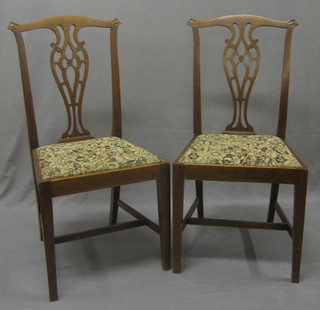 A set of 4 Chippendale style mahogany chairs with carved backs and upholstered seats raised on square supports