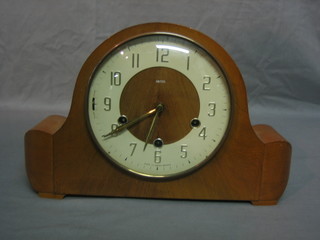 A 1950's Smiths chiming mantel clock contained in an arched walnut case with Arabic numerals