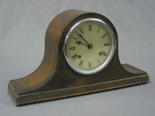 A striking mantel clock with silvered dial and Roman numerals contained in an oak Admiral's hat shaped case