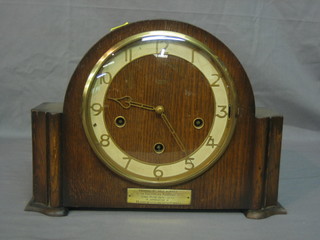 A 1930's chiming mantel clock with Arabic numerals contained in an oak arch shaped case