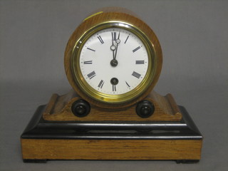 A Victorian 8 day mantel clock with enamelled dial and Roman numerals contained in a mahogany drum case
