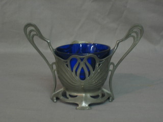 A Continental Art Nouveau pierced pewter twin handled bowl with blue glass liner raised on bracket feet, the base marked Juventa Premier 4"