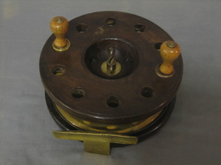 A large wooden and brass centre pin fishing reel 7"