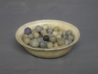 An oval jelly mould containing various old marbles