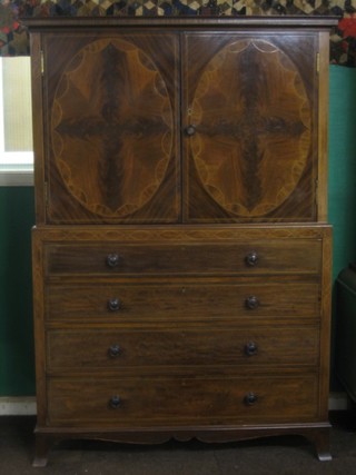 An Edwardian inlaid mahogany linen press, the upper section fitted shelves enclosed by arch shaped inlaid panelled doors, the base fitted 4 long graduated drawers with tore handles, raised on splayed bracket feet 43"