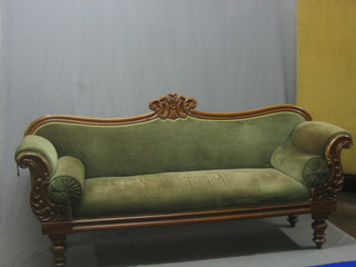 A William IV mahogany show frame sofa upholstered in green material, raised on turned supports 81"