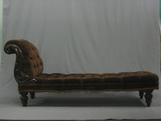 A Victorian mahogany show frame day bed upholstered in brown buttoned back material, raised on turned supports 74"